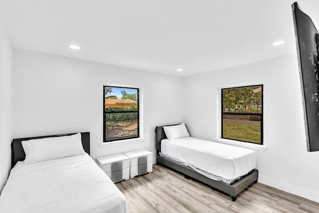 bedroom with recessed lighting, multiple windows, and light wood finished floors