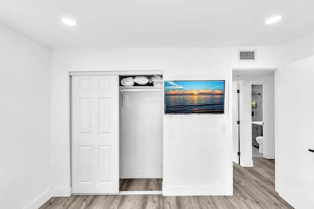 unfurnished bedroom featuring baseboards, visible vents, and light wood-style floors