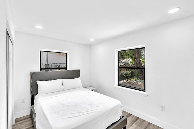 bedroom with light wood-type flooring, baseboards, and recessed lighting