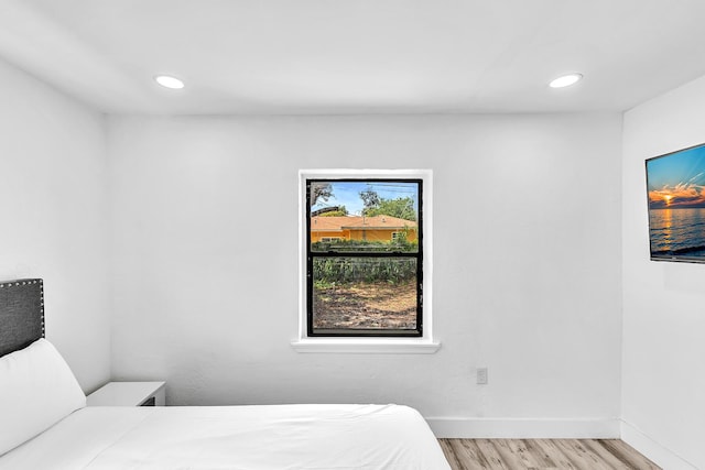 bedroom featuring baseboards, wood finished floors, and recessed lighting