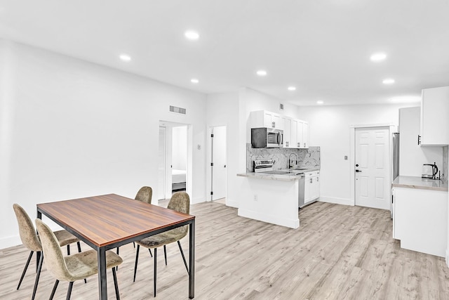 dining area with light wood-style floors, baseboards, visible vents, and recessed lighting