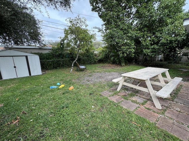 view of yard featuring an outdoor structure, fence, and a storage unit