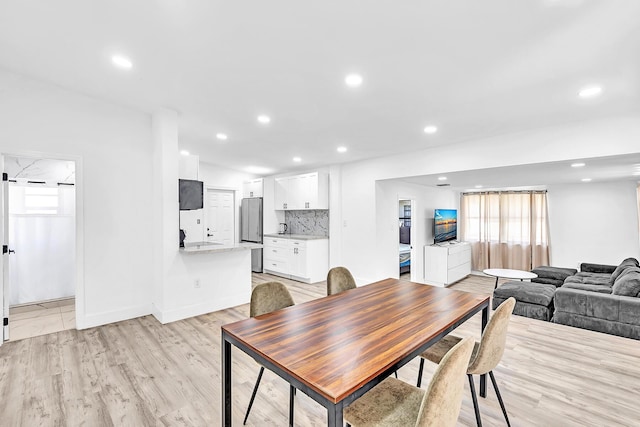 dining area with baseboards, light wood-style floors, and recessed lighting