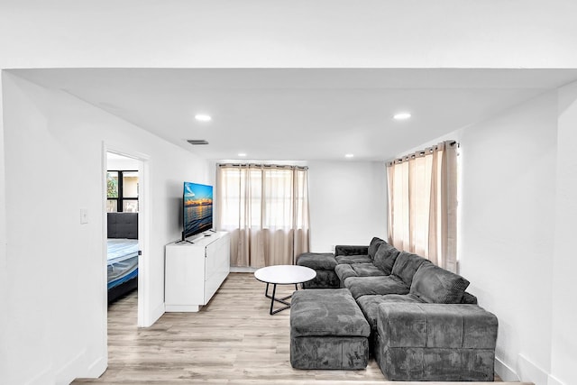 living area featuring light wood-type flooring, baseboards, a wealth of natural light, and recessed lighting