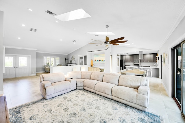 living room featuring light tile patterned floors, a ceiling fan, visible vents, and ornamental molding