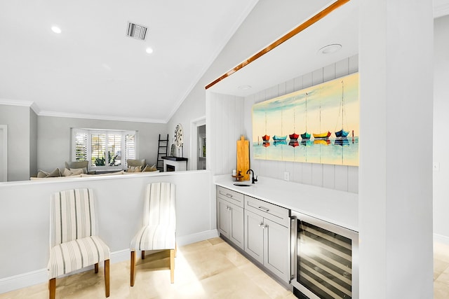 bar with beverage cooler, visible vents, ornamental molding, and a sink