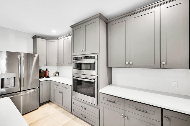 kitchen with gray cabinets, stainless steel appliances, and light countertops