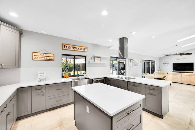 kitchen featuring a peninsula, black electric cooktop, gray cabinets, and a kitchen island