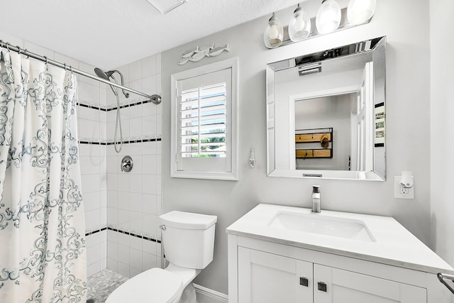 bathroom featuring tiled shower, toilet, and vanity