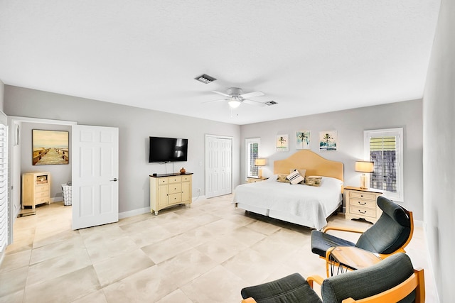 bedroom featuring visible vents, ceiling fan, baseboards, light tile patterned flooring, and a closet