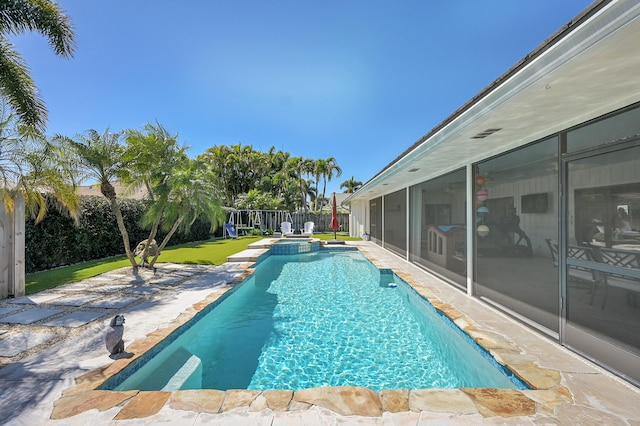 view of pool featuring a patio, a pool with connected hot tub, a fenced backyard, and a sunroom