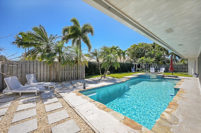 view of swimming pool with a patio area, a pool with connected hot tub, and a fenced backyard