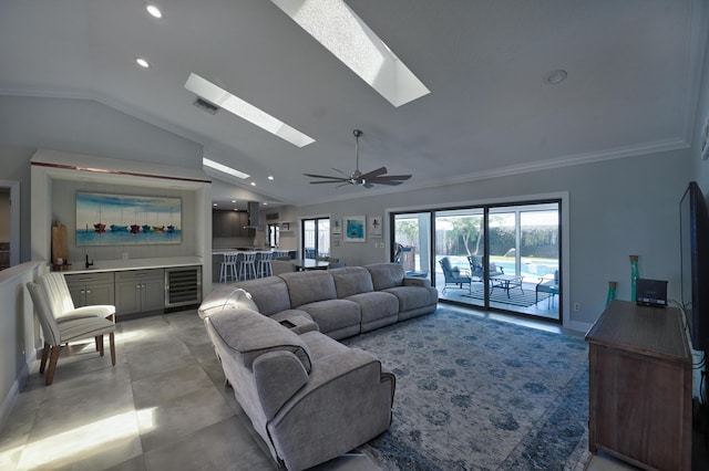 living area featuring wine cooler, plenty of natural light, lofted ceiling with skylight, and visible vents