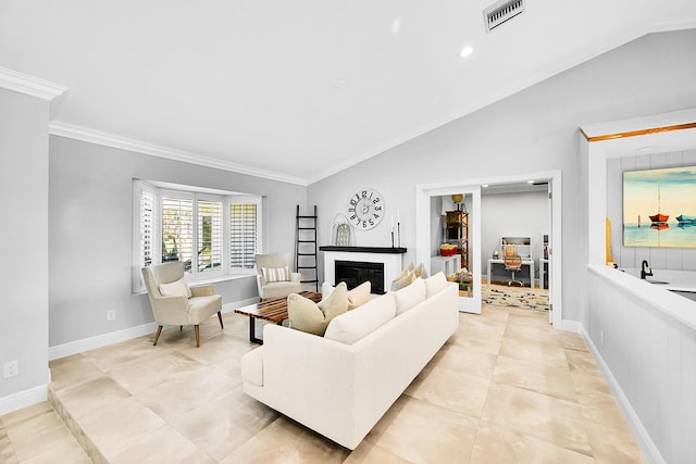 living room featuring visible vents, ornamental molding, a glass covered fireplace, and vaulted ceiling