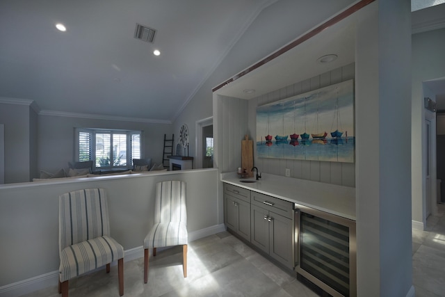 bar with visible vents, crown molding, beverage cooler, lofted ceiling, and a sink