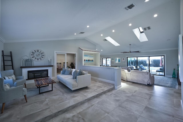 living area featuring a glass covered fireplace, crown molding, vaulted ceiling with skylight, and visible vents