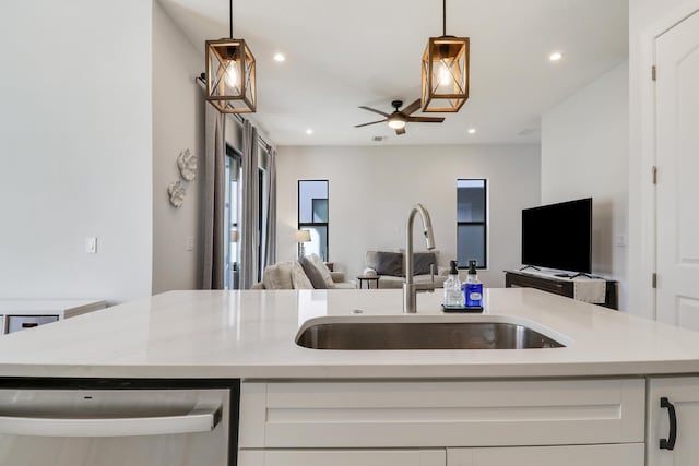 kitchen with open floor plan, white cabinetry, a sink, and dishwasher