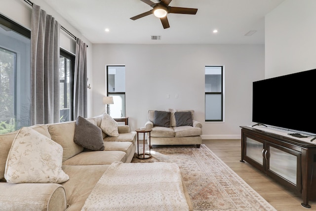 living area with light wood-style floors, recessed lighting, visible vents, and a ceiling fan