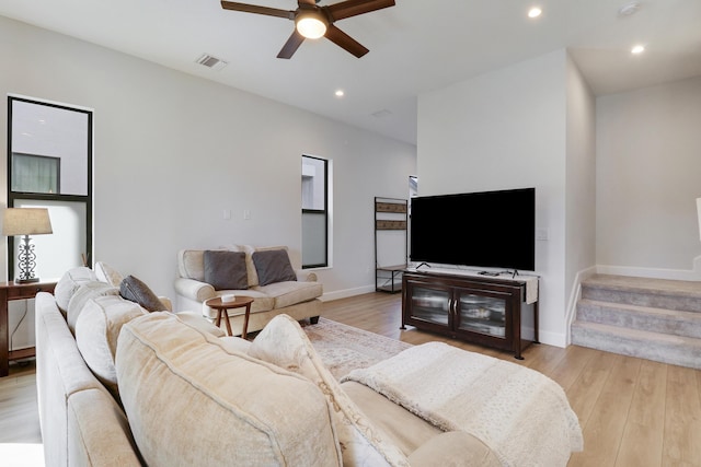 living room with visible vents, baseboards, ceiling fan, light wood-style floors, and recessed lighting