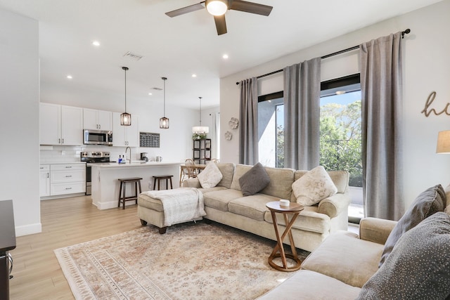 living area with recessed lighting, light wood-type flooring, visible vents, and a ceiling fan