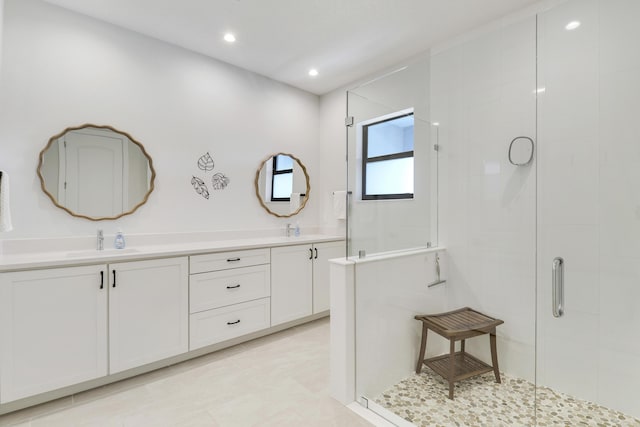 bathroom with a stall shower, a sink, and double vanity