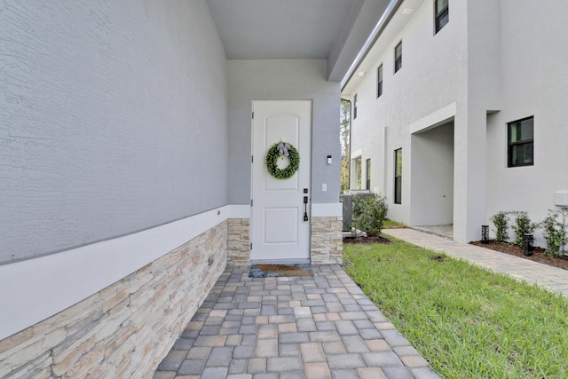 doorway to property featuring stucco siding