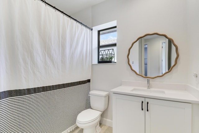 bathroom featuring curtained shower, vanity, and toilet