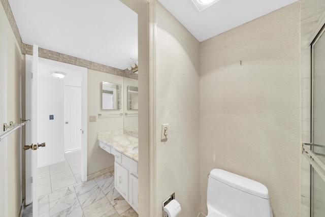 bathroom featuring marble finish floor, baseboards, vanity, and toilet