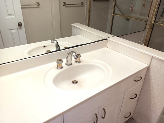 bathroom featuring tiled shower and vanity