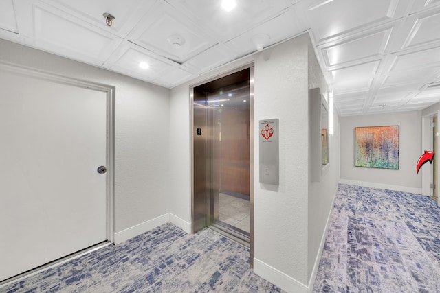 hall featuring elevator and baseboards