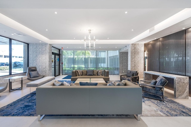 living area with a chandelier, expansive windows, a tray ceiling, and recessed lighting