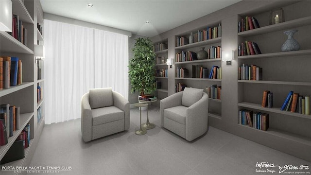 sitting room featuring bookshelves, plenty of natural light, and built in shelves