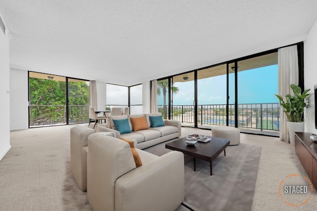 living room featuring floor to ceiling windows, a textured ceiling, and light colored carpet