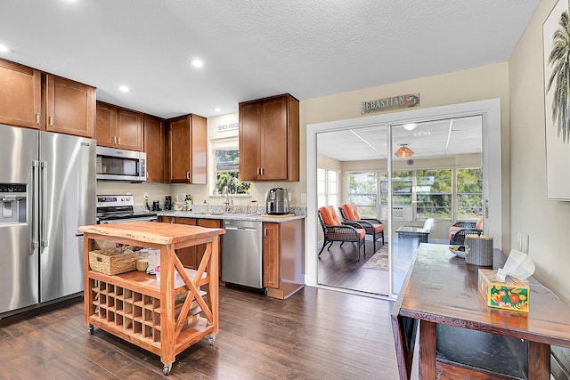 kitchen featuring recessed lighting, dark wood-type flooring, appliances with stainless steel finishes, and a textured ceiling