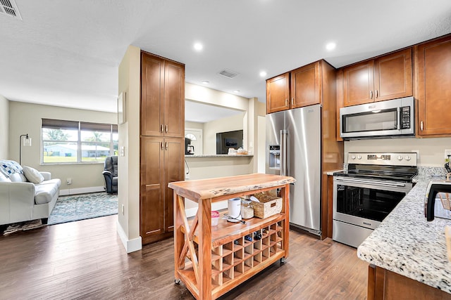 kitchen with stainless steel appliances, dark wood-type flooring, visible vents, and open floor plan