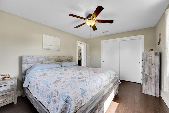 bedroom with visible vents, a closet, baseboards, ceiling fan, and dark wood-style flooring