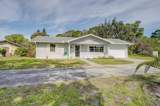 ranch-style house with a front yard, a garage, and driveway