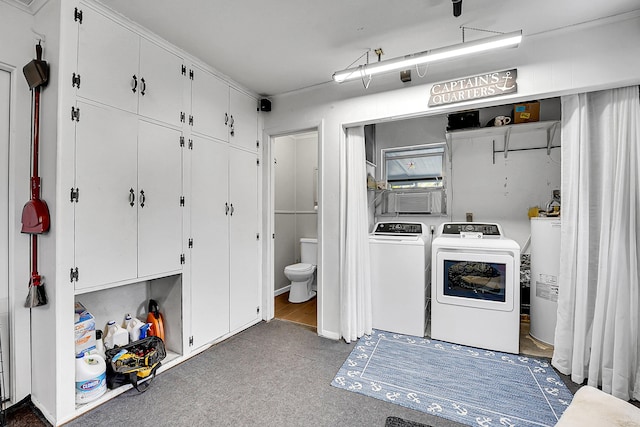 clothes washing area with water heater, laundry area, and washer and dryer