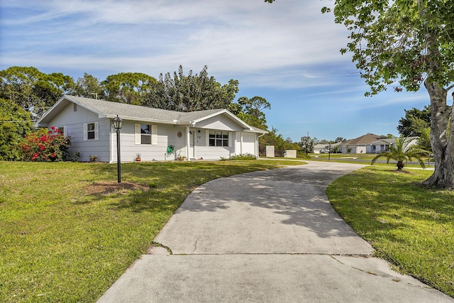 ranch-style house featuring concrete driveway and a front lawn