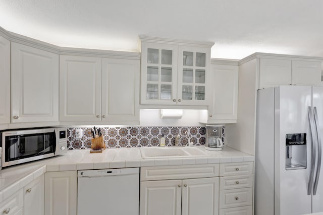 kitchen with fridge with ice dispenser, white dishwasher, a sink, and white cabinets