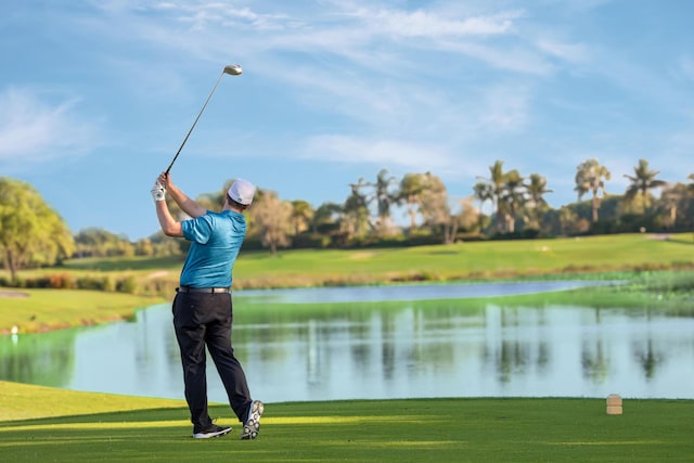 view of community with a yard, golf course view, and a water view