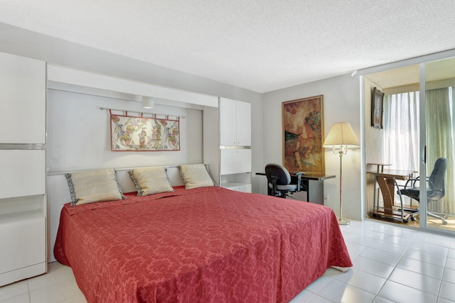 bedroom featuring expansive windows, a textured ceiling, and light tile patterned floors