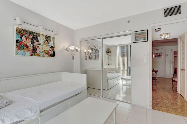 bedroom featuring a closet, visible vents, and light tile patterned floors