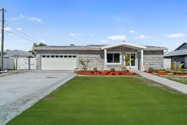 view of front facade featuring a garage, fence, concrete driveway, roof mounted solar panels, and a front lawn