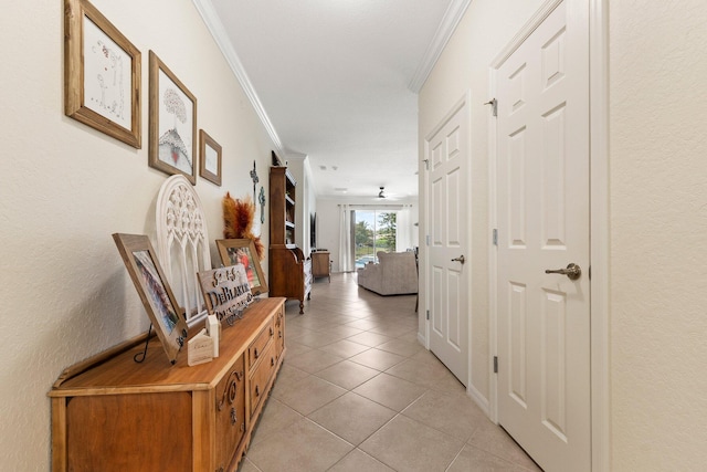 hall with light tile patterned floors and crown molding