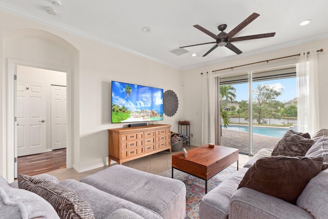 tiled living area with ceiling fan, arched walkways, recessed lighting, baseboards, and crown molding