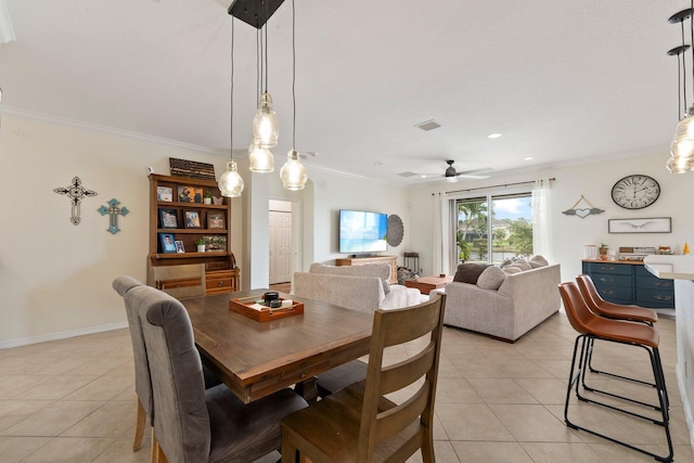 dining space with light tile patterned floors, ceiling fan, ornamental molding, and baseboards