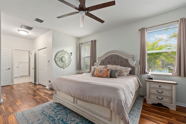 bedroom featuring baseboards, visible vents, and wood finished floors