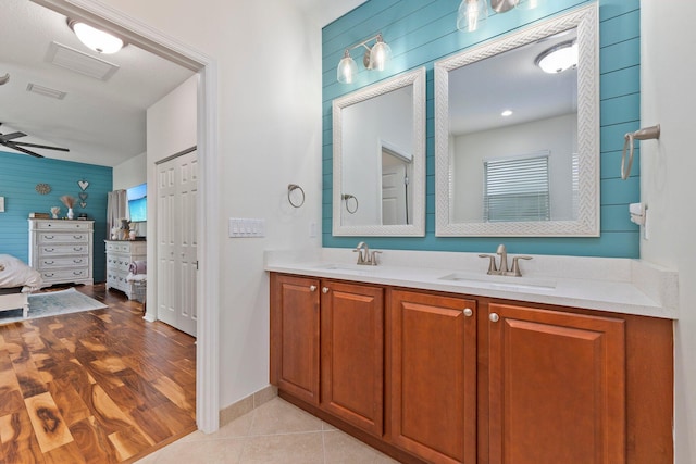 bathroom featuring double vanity, tile patterned flooring, a sink, and ensuite bathroom