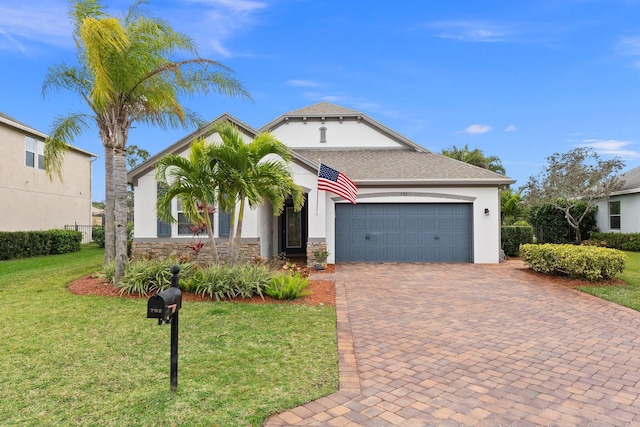 view of front facade with stone siding, stucco siding, an attached garage, decorative driveway, and a front yard